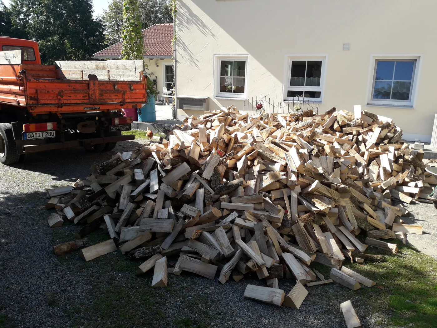 Geliefertes Brennholz lose vor einem Wohnhaus