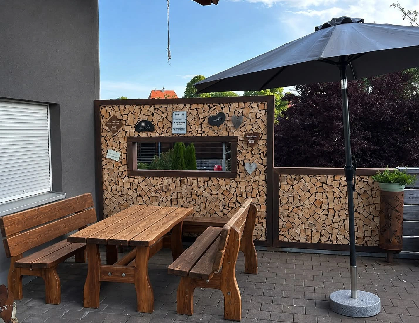 Brennholz als dekorativer Sichtschutz auf einer Terrasse